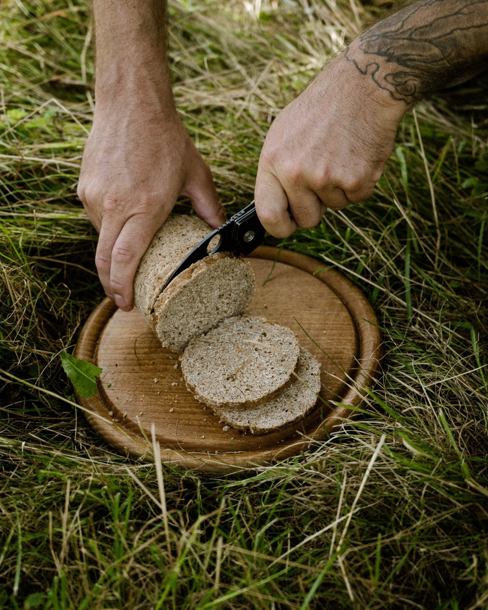 Ein Stück Deiser's Roggenmischbrot aus der Dose wir gerade mit einem Outdoor-Klappmesser zu Scheiben geschnitten.