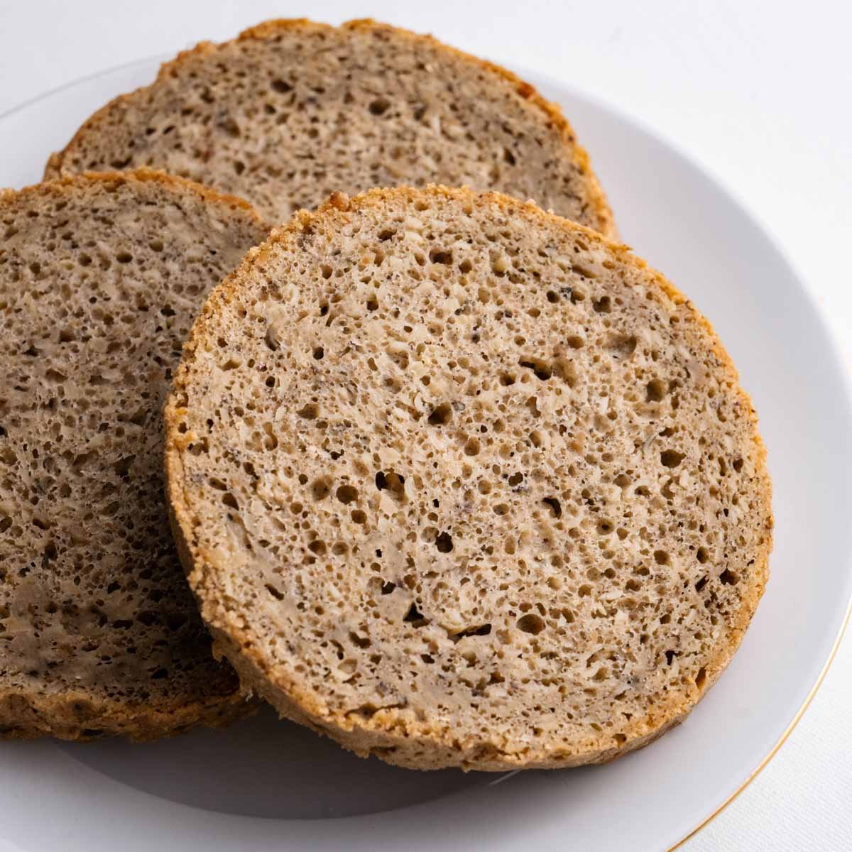 Das Hanfbrot aus der Dose von Deiser's Dosenbrot in runde Brotscheiben aufgeschnitten und gefächert, die feine Krume mit den geschälten Hanfsamen ist gut zu sehen.