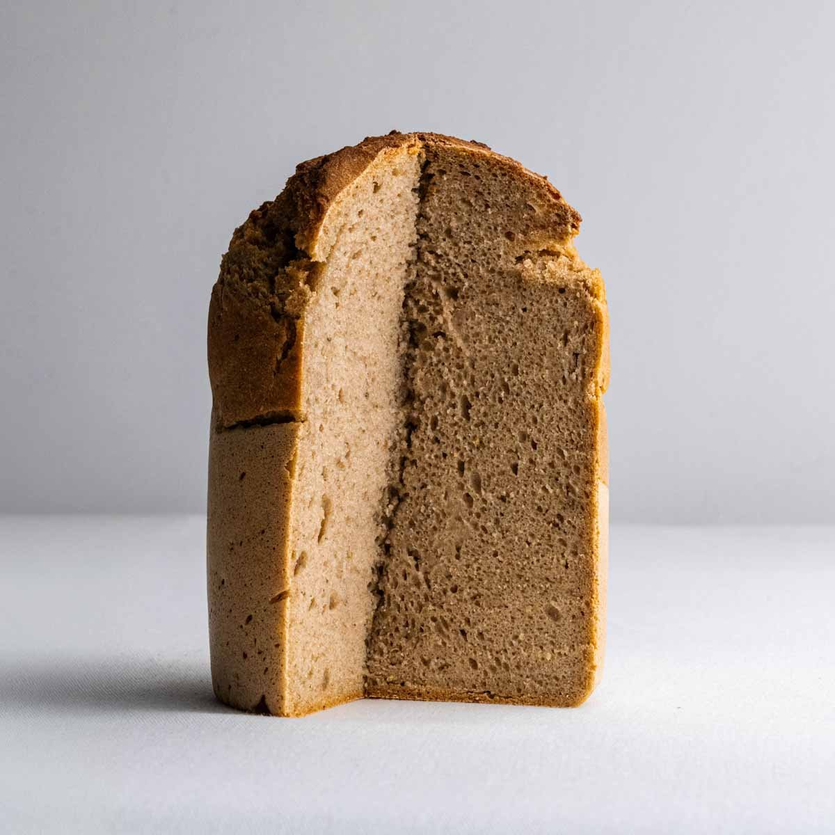 Das Roggenmischbrot aus der Dose von Deiser's naturally baked goods angeschnitten, sodass die kompakte Krume des Roggenbrots gut zu sehen ist.