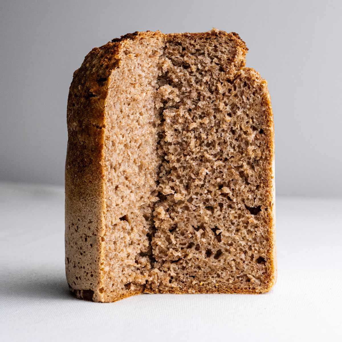 Das Roggenvollkornbrot aus der Dose von Deiser's naturally baked goods, gebacken in Österreich, angeschnitten, sodass die feinporige Krume des Roggenbrots gut zu sehen ist.