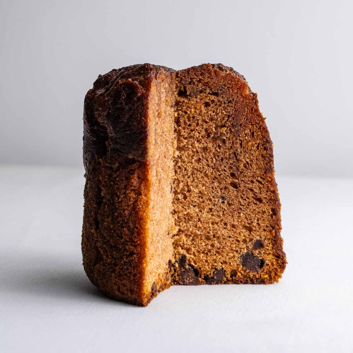 Der Schokokuchen aus der Dose von Deiser's naturally baked goods, gebacken in Österreich, angeschnitten, sodass die mitgebackenen Schokoladenstückchen gut zu erkennen sind.